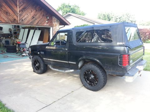 1994 Ford Bronco - This 1994 Ford Bronco is parked in front of a garage with its soft top installed.
