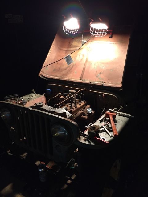 1946 Jeep Willys - Working on the engine of a 1946 Jeep CJ5 at night with work lights.