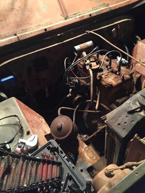 1946 Jeep Willys - A close-up view of the engine bay of a 1946 Jeep CJ5, showing mechanical components and tools.
