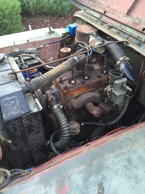 1946 Jeep Willys - The engine bay of a 1946 Jeep CJ5 shows its inline-four engine, radiator, and battery.