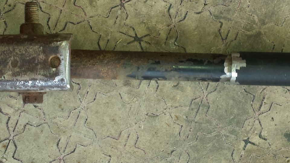 Metal rod with bolt and white tape on a patterned surface