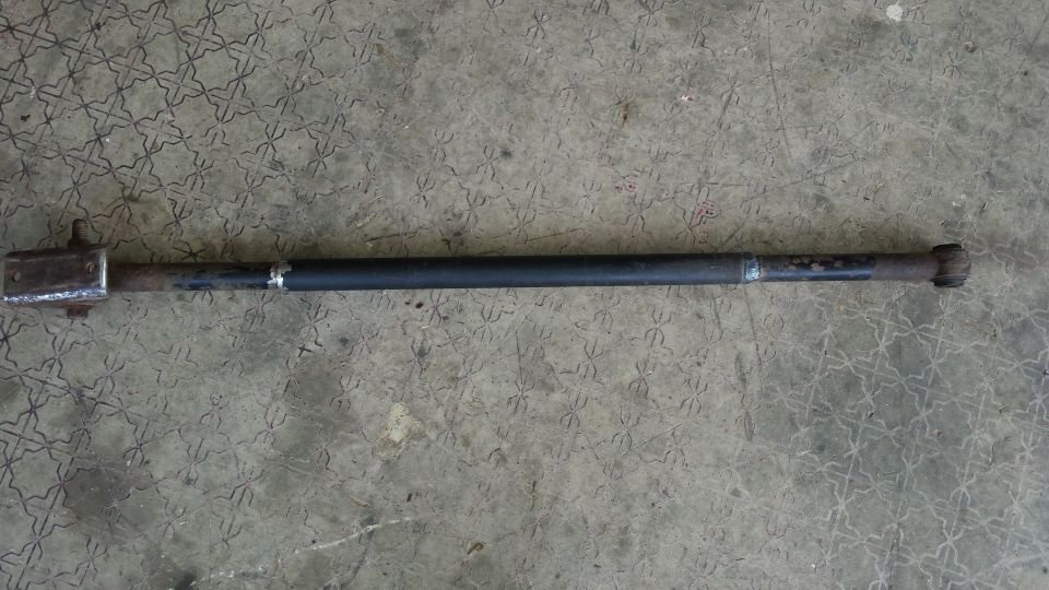 Metal rod with welded ends, one end has a square bracket attached