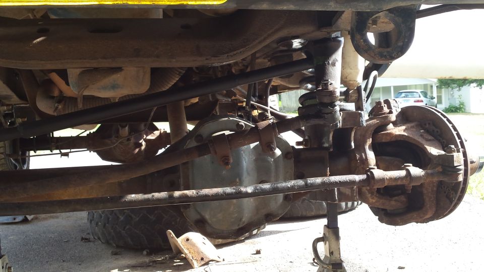Undercarriage view of front axle and suspension components. Supermotors.net logo visible