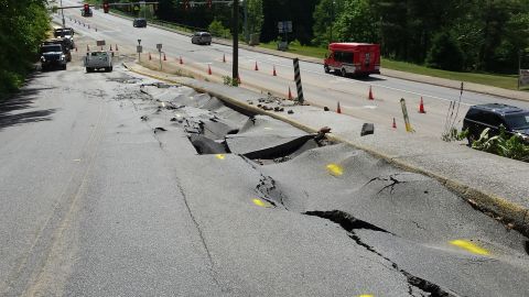 1979 Ford Bronco - A road has collapsed, with traffic cones and vehicles present at the scene.