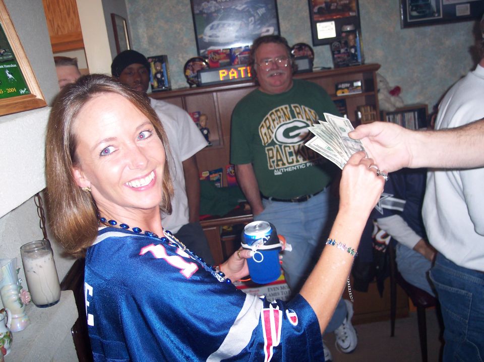 Woman in a blue jersey holds a can and money is exchanged between hands