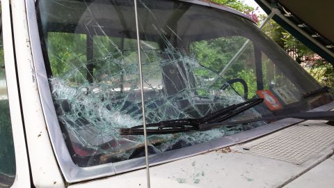 1979 Ford Bronco - The windshield of a vehicle is heavily damaged, with glass cracked all over.