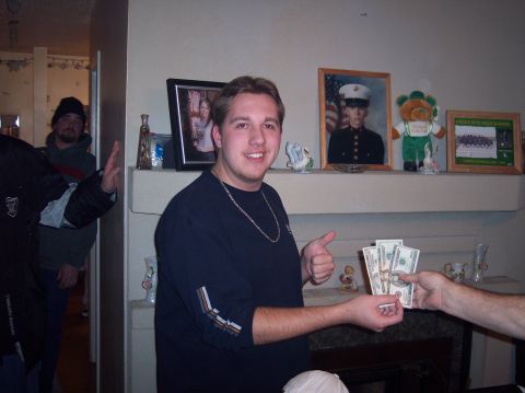 1990 Ford Bronco - A man gives cash to another person while standing indoors with decorations on a shelf.