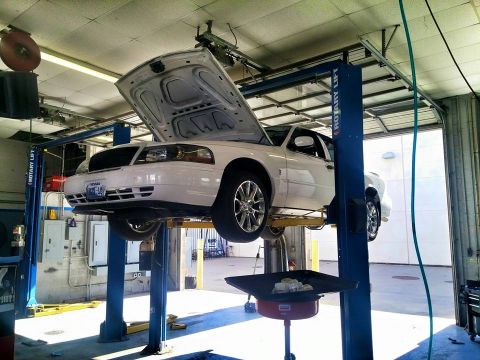2000 Mercury Grand Marquis - White 2000 Mercury Grand Marquis on a car lift in a service bay.