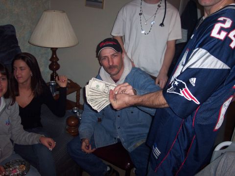 1990 Ford Bronco - Several people are gathered in a room, with one man displaying a wad of cash.