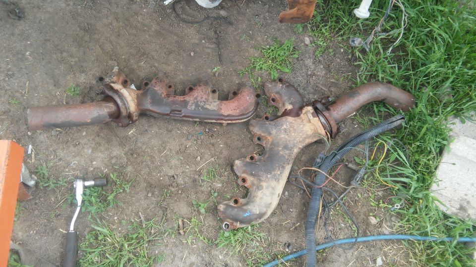 Pair of rusty exhaust manifolds on the ground
