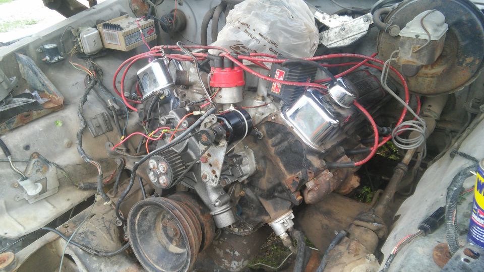 V8 engine with chrome valve covers and red spark plug wires in an engine bay