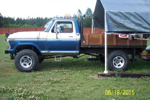 1973 Ford F-250 - Side view of a 1973 Ford F-250 flatbed truck with a wooden bed, parked outdoors.