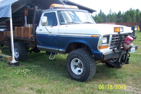1973 Ford F-250 - This truck features a flatbed with wooden sides and a plow attachment on the front bumper.