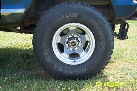 1973 Ford F-250 - Close-up of a truck's wheel and tire, with part of the blue body visible.