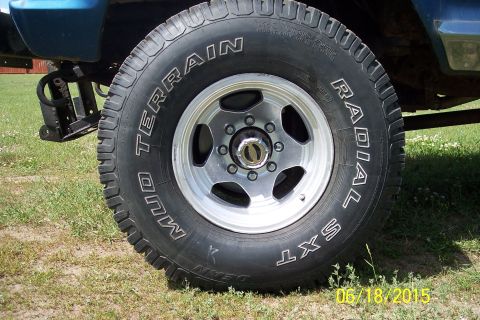 1973 Ford F-250 - A close-up view of a Mud Terrain Radial SXT tire and wheel assembly on a vehicle.