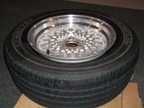 1999 Mercury Grand Marquis - A chrome mesh wheel is placed on top of a Michelin Symmetry tire, with a Supermotors.net watermark visible.