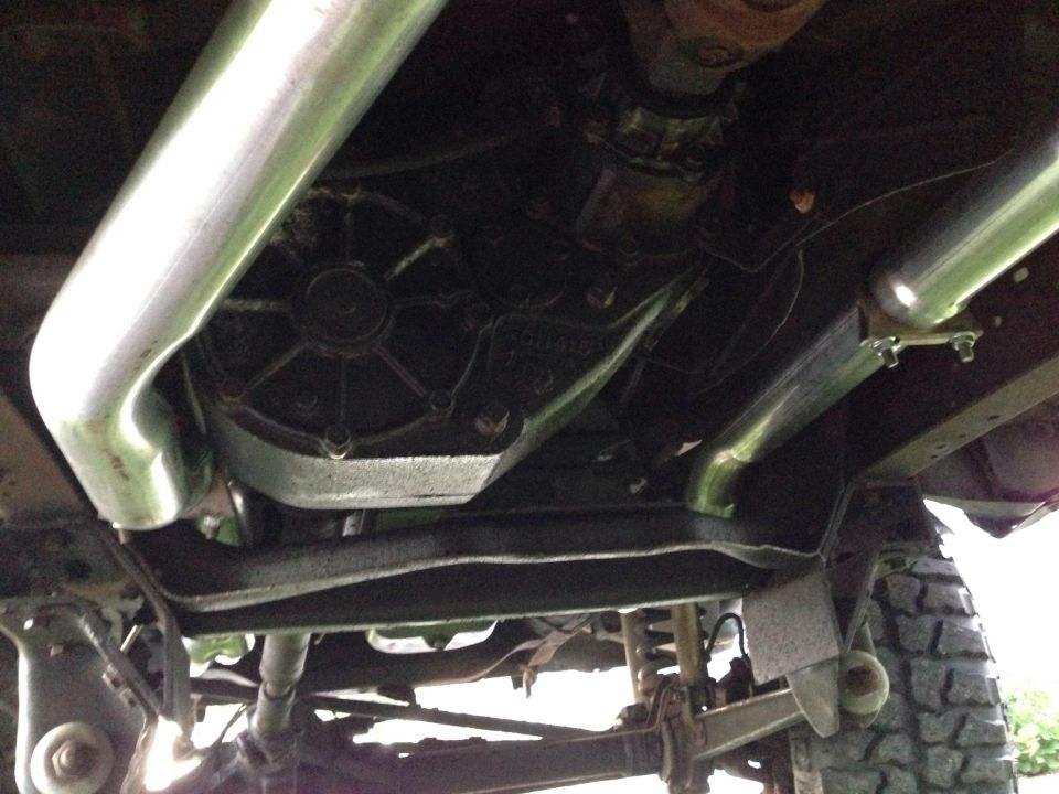Undercarriage view of a vehicle's drivetrain and exhaust system, with Supermotors.net watermark