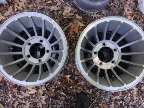 1979 Ford Bronco - Two aluminum alloy wheels are shown from a top-down perspective on the ground.