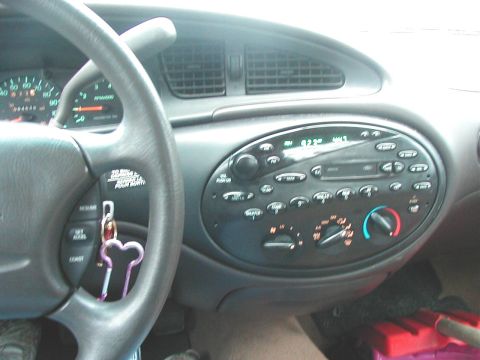 1997 Ford Taurus - The interior of a 1997 Ford Taurus is visible, focusing on the dashboard with the steering wheel and radio.