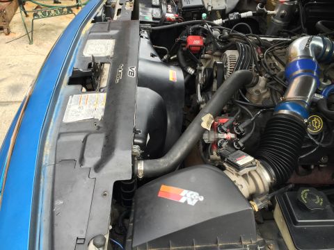 1994 Ford Crown Victoria - Close-up view of a vehicle's engine bay, showing the V8 engine and aftermarket air intake system.