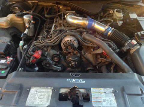 1994 Ford Crown Victoria - The engine bay of a 1994 Ford Crown Victoria is visible, a V8 4.6L engine with some aftermarket modifications.