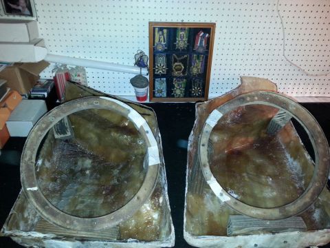 1996 Ford Bronco - Two unfinished fiberglass speaker enclosures with metal mounting rings are displayed on a table.