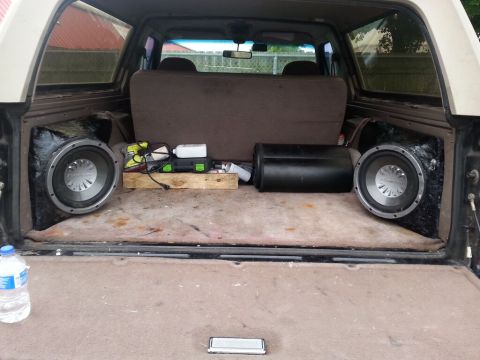 1996 Ford Bronco - The cargo area of an SUV is fitted with aftermarket subwoofers and audio equipment.