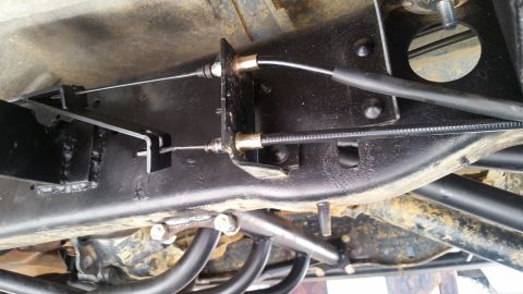1988 Ford Bronco - Underside view of a vehicle's brake cable system, showing the routing and attachment points.