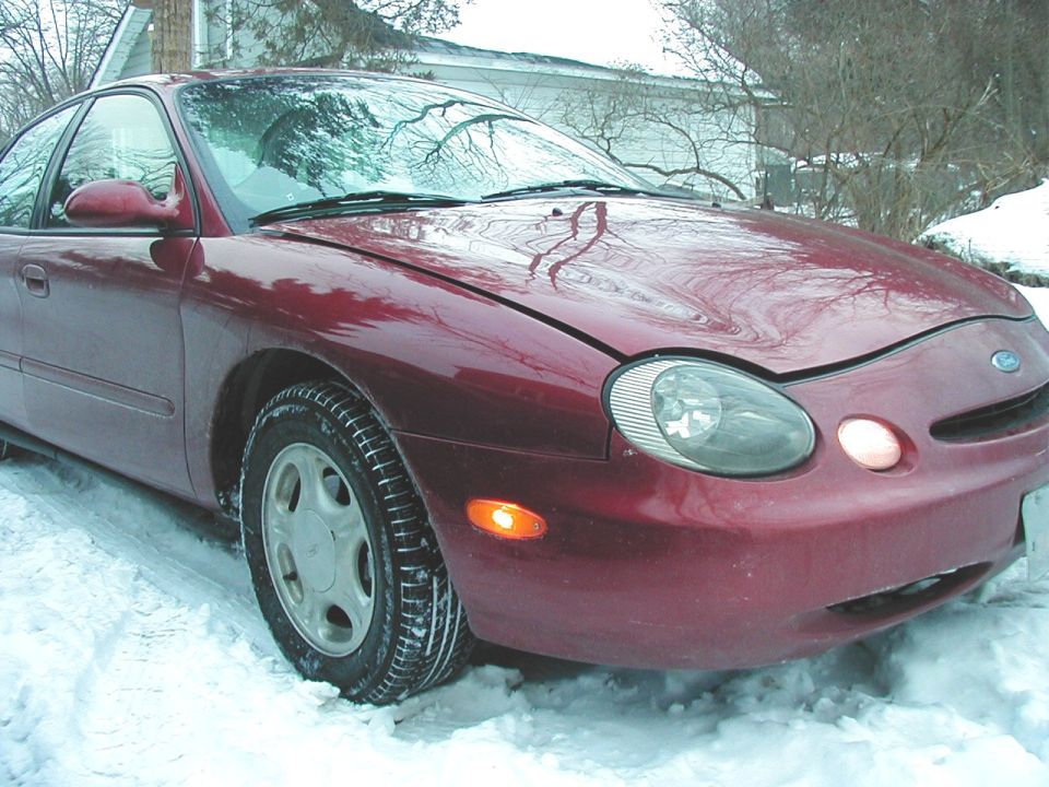 Red 1997 Ford Taurus parked in snow