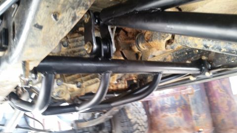 1988 Ford Bronco - This photo shows the undercarriage of a vehicle, highlighting custom roll cage and suspension parts.