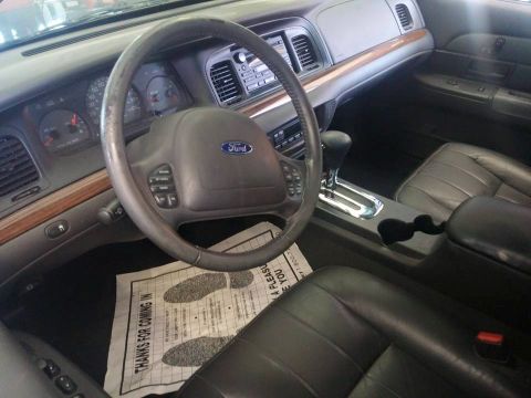 2000 Mercury Grand Marquis - The interior of a Ford Crown Victoria, a leather seat and a Ford-branded steering wheel.