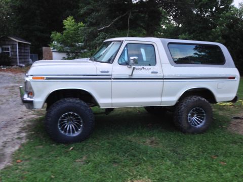 1979 Ford Bronco - This 1979 Ford Bronco is shown from the side, a white body with a grey removable top and custom wheels.