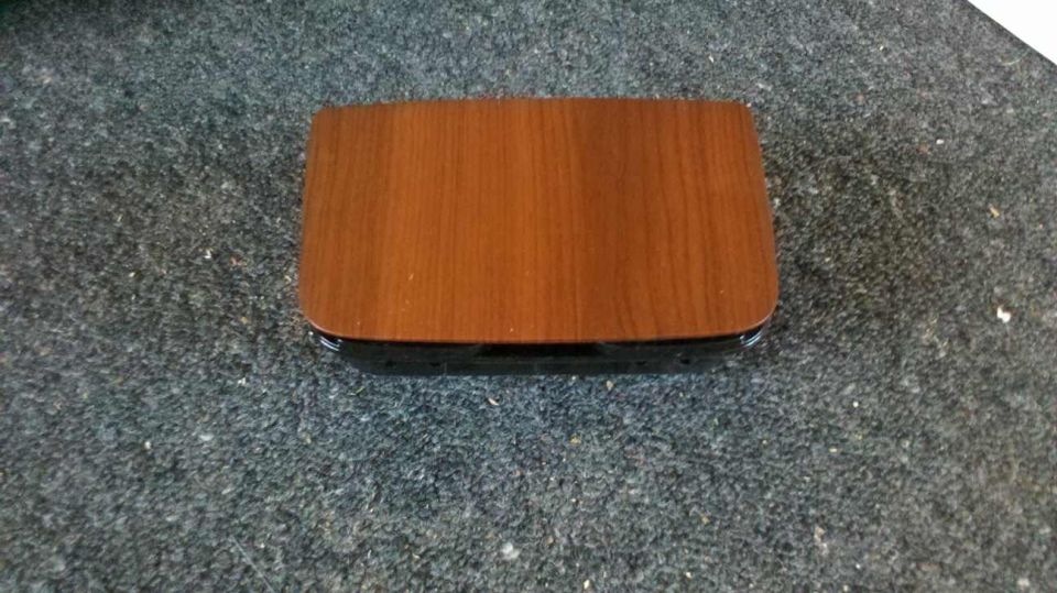 Wooden box with black base on a dark textured surface