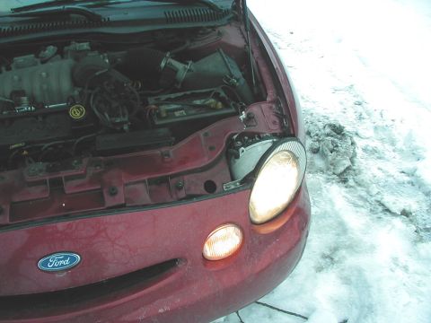 1997 Ford Taurus - Front view of a 1997 Ford Taurus with the hood open, revealing the engine compartment.