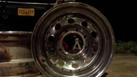 Chrome wheel with bolt holes, Virginia license plate 722 OTP on dark vehicle.