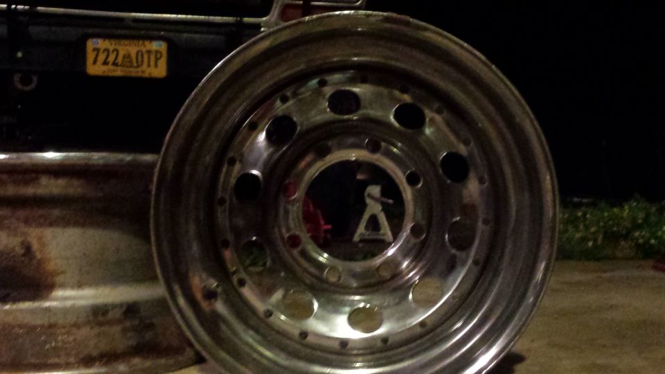 Chrome wheel with bolt holes, Virginia license plate 722 OTP on dark vehicle.