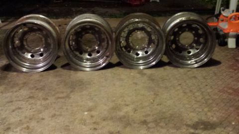 Four polished aluminum alloy wheels with multi-lug pattern and deep dish design.