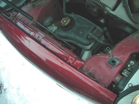 1997 Ford Taurus - The engine bay of a red vehicle is shown, with various components visible.