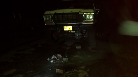 Lifted 1979 Ford Bronco front view at night, headlights on, yellow license plate "722 UTP"