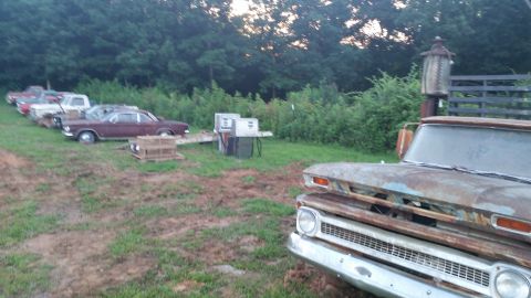 2015 Chevrolet new - A rusty, vintage pickup truck is parked in a grassy lot with several other older vehicles and a vintage gas pump in the background. The tru…