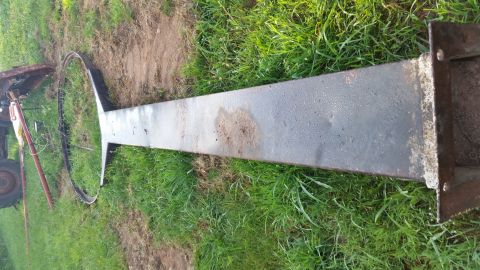 2015 Chevrolet new - A long, dark metal beam with a circular metal ring attached to one end is lying on the grass. The beam appears to be part of a larger struc…