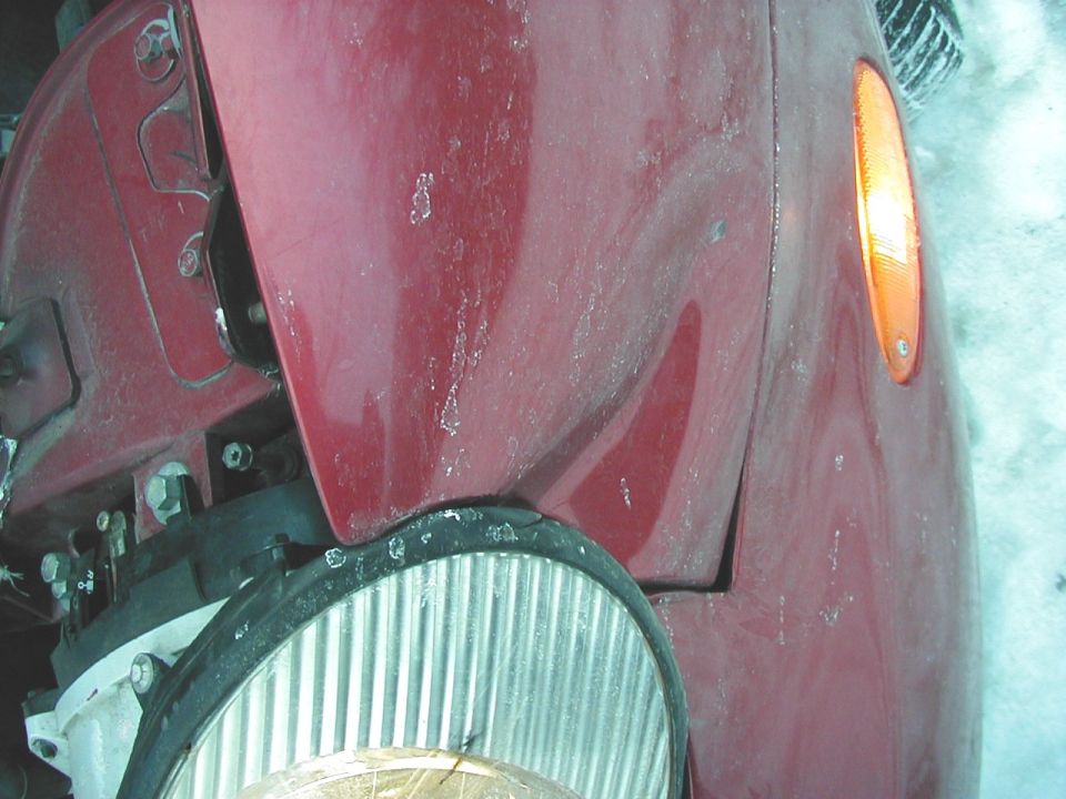 Red 1997 Ford Taurus front fender with amber turn signal and exposed wheel