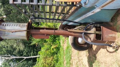 2015 Chevrolet new - A close-up view of the rusty rear axle and suspension components of a vintage vehicle, with a black hose and nozzle attached to the differe…