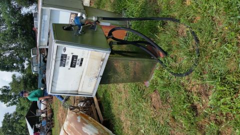 2015 Chevrolet new - A vintage CITGO gasoline pump with two hoses and nozzles sits outdoors next to a classic green truck. A man in a green shirt and blue jeans…
