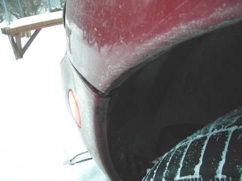 1997 Ford Taurus - Red car fender and tire visible in a snowy environment.