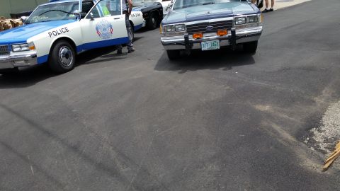 1991 Ford LTD Crown Victoria - Photograph of vintage police cars parked on pavement, not a technical document.