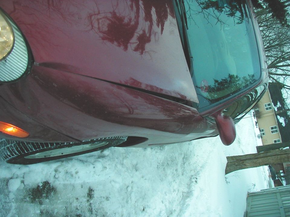 Red 1997 Ford Taurus in snow, front 3/4 view