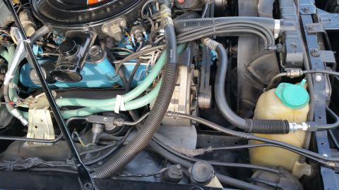 1991 Ford LTD Crown Victoria - Photograph of a vintage engine bay with hoses and reservoir, not a technical document.