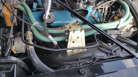 1991 Ford LTD Crown Victoria - Photograph of an engine bay with teal valve cover, green spark plug wires and accessory brackets, not a technical document.