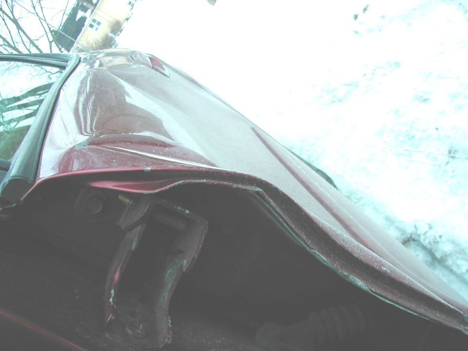 Red car fender damage, close-up view